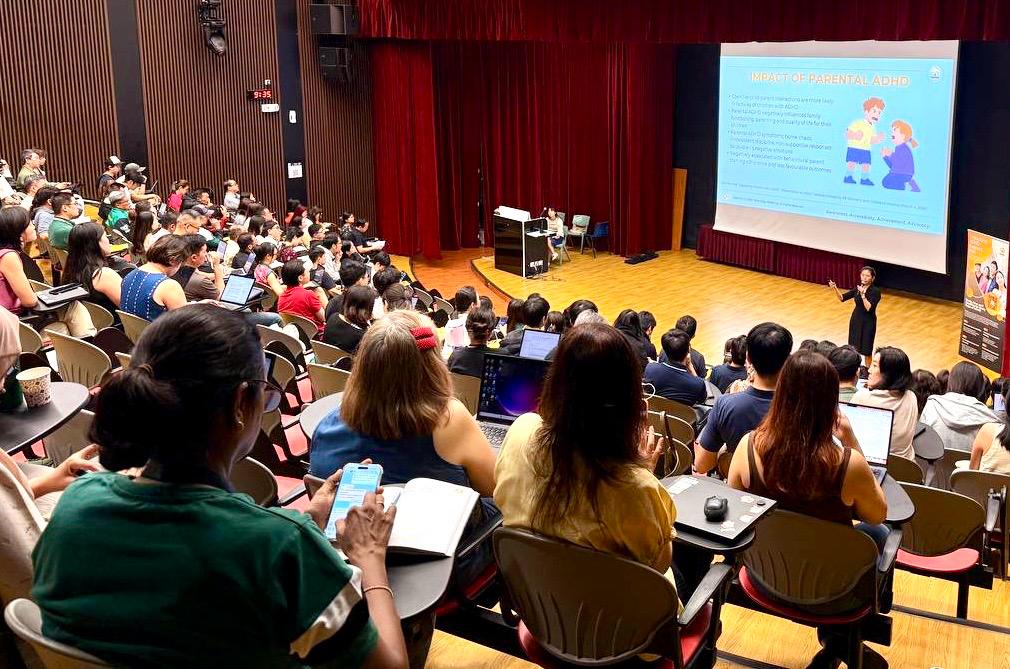 Moonlake Lee presenting to a full auditorium